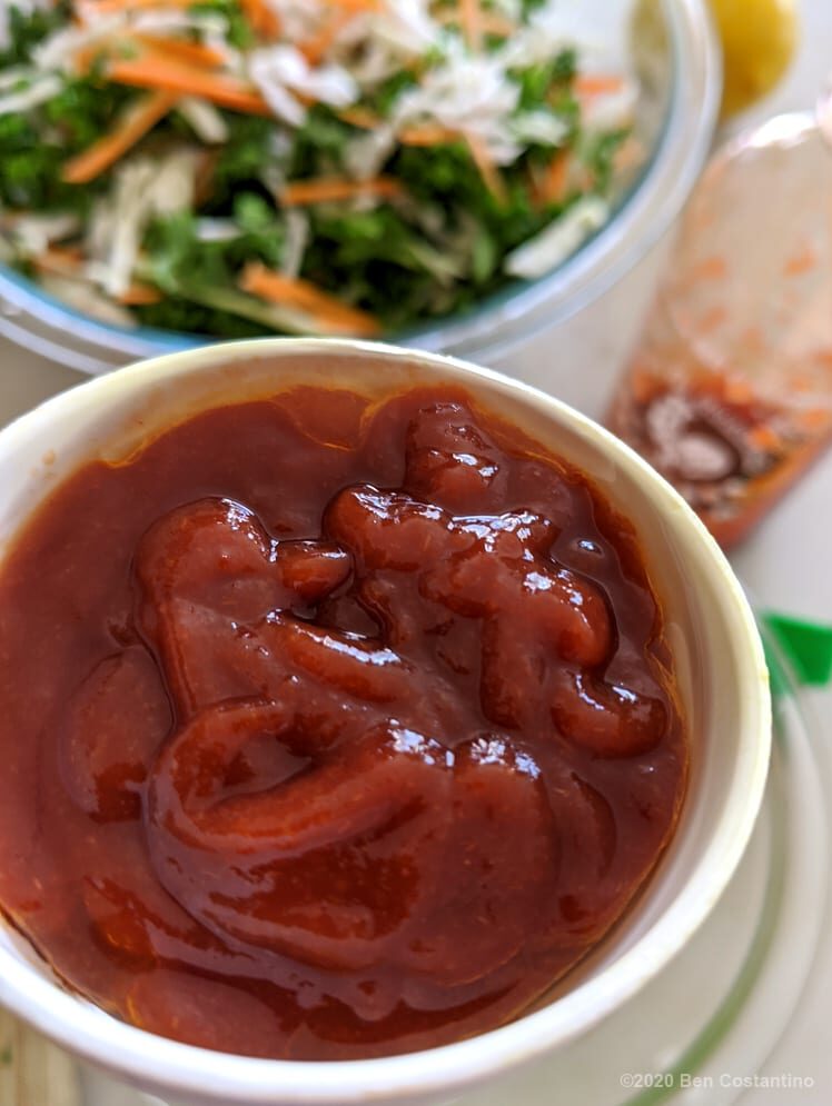 Sriracha sauce being added to kale slaw