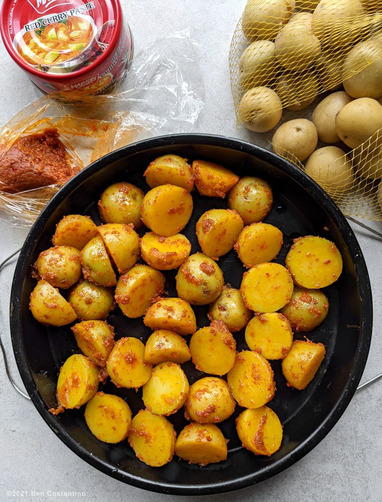 potatoes in curry paste in an air fryer pan