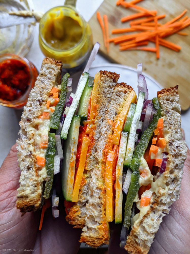 vegetarian sandwich with hummus, cheese, and Calabrian pepper spread